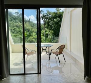 Habitación con mesa, 2 sillas y ventana en The Green Golf Apartments en Ban Thung Thong