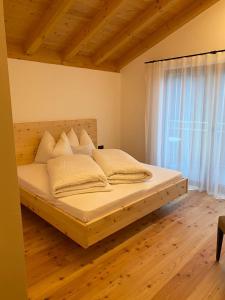 ein großes Bett in einem Zimmer mit Fenster in der Unterkunft Innerpasthof 