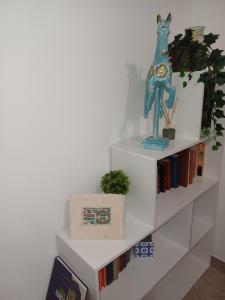 una mensola bianca con libri e un orologio di Le Stanze di Bimba a Terni