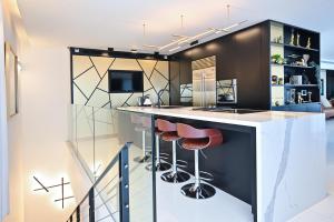 een keuken met een bar met krukken en een tv bij Luxurious 3BR Penthouse with Jacuzzi by HolyGuest in Tel Aviv