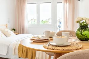 Una habitación con una mesa con tazas de café y una cama en Estudio Bianca en L'Escala