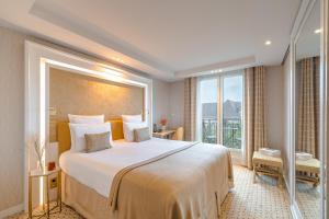um quarto de hotel com uma cama grande e uma janela em Hôtel Madison em Paris