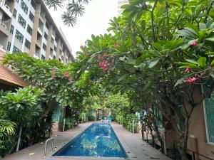 a swimming pool in the middle of a building with trees at BBHOUSE pattaya in Pattaya South