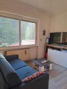 een woonkamer met een bank en een flatscreen-tv bij Appartamento Varazze in Varazze