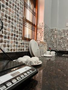 a kitchen with a counter with plates and dishes on it at Happy Homes in Varanasi