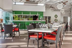 a dining room with tables and chairs and a green bar at Club del Carmen in Puerto del Carmen