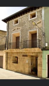 un edificio de ladrillo con balcón en la parte superior en Casa rural marga, en Tardienta