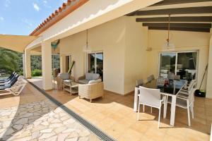 a patio with a table and chairs and a house at Villa Rosa in Calonge