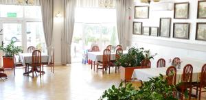 jadalnia ze stołami, krzesłami i oknami w obiekcie Restauracja Kargul noclegi w mieście Łęczyca