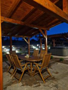 a wooden table and chairs on a patio at Ruralna kuća za odmor - Bitunjac in Levanjska Varoš