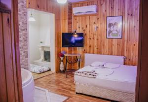 a bedroom with a bed and a television and a bathroom at Ayisigi Hotel in Ağva