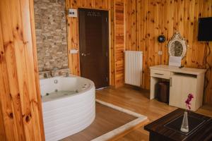 Un baño con una bañera grande en una habitación de madera. en Ağva Ayışığı Otel, en Agva
