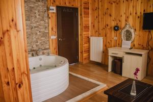 Habitación de madera con baño con bañera grande. en Ayisigi Hotel, en Agva