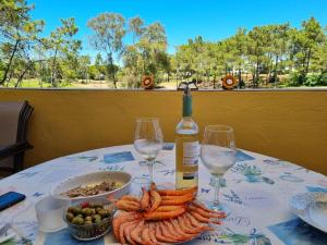 a table with a bottle of wine and wine glasses at Laguna Golf, Hoyo 17, Islantilla in Islantilla
