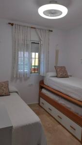a bedroom with two twin beds and a window at Laguna Golf, Hoyo 17, Islantilla in Islantilla