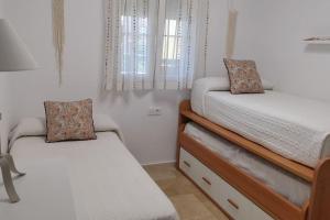 a small bedroom with two beds and a window at Laguna Golf, Hoyo 17, Islantilla in Islantilla +27 photos