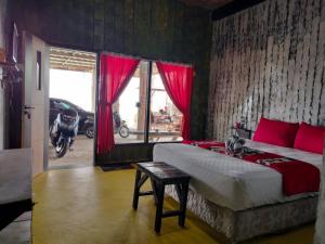 ein Schlafzimmer mit einem großen Bett mit roten Kissen in der Unterkunft Wanagiri Sikihomestay in Gitgit