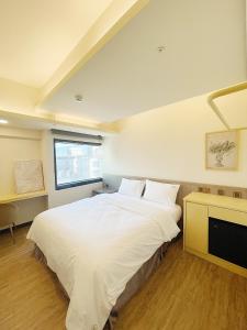 a bedroom with a large white bed and a window at Hermit Dorm in Taipei