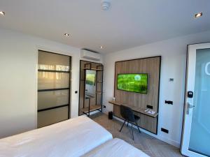 1 dormitorio con 1 cama y TV en la pared en HarTeluk Afsluitdijk Zurich en Zurich