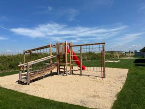 a playground with a red slide in a park at Haus Traubeneiche in Büsum