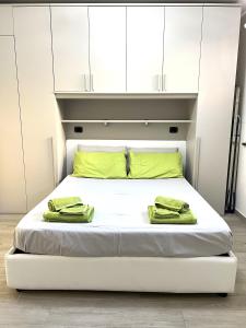 a bed with white cabinets and green towels on it at Green House Varazze in Varazze