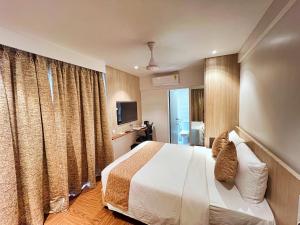 a hotel room with a bed and a television at White House by Maxxvalue Service Apartments Bandra in Mumbai