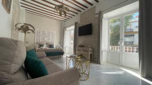 un soggiorno con divano e TV di Adriano by Global a Siviglia