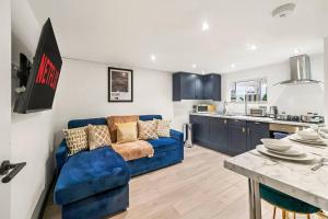 卡斯爾福德的住宿－Stunning Yorkshire Gem - Sleeps 4，一间带蓝色沙发的客厅和一间厨房