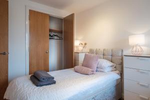 a bedroom with a bed with two pillows on it at Mackie Residence - 3 Bed Apartment with parking in Westhill 