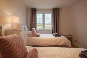 sypialnia z 2 łóżkami i oknem w obiekcie Mackie Residence - 3 Bed Apartment with parking w mieście Westhill
