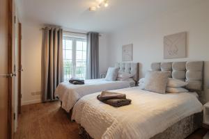 een slaapkamer met 2 bedden en een raam bij Mackie Residence - 3 Bed Apartment with parking in Westhill 