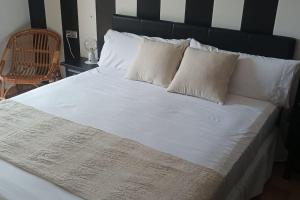 a large bed with white sheets and pillows at Apartament a L’Estartit x 4 in Torroella de Montgrí