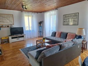 ein Wohnzimmer mit einem Sofa und einem Flachbild-TV in der Unterkunft Two-bedroom apartment with sea view in Stari Grad