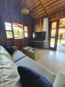 Una sala de estar con un sofá y un televisor de pantalla plana. en Chalé em Maragogi, en Maragogi