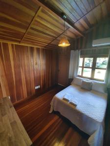Un dormitorio con una cama grande en una habitación de madera. en Chalé em Maragogi, en Maragogi 11 fotos más