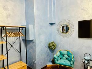 una stanza con una sedia e uno specchio a muro di RarityArt GuestHouse a Salerno