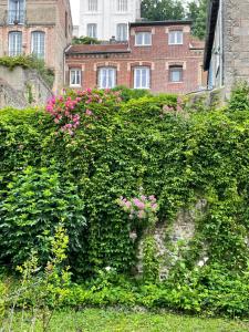 een heg met roze bloemen bovenop een gebouw bij Le Grand apartment dan Dieppe - Charming home 2-8 guests in Dieppe