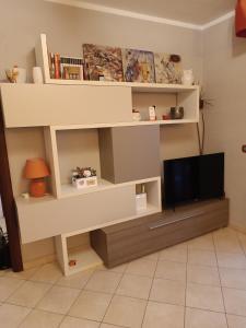 a living room with a tv and shelves at Dario's house in Sassari