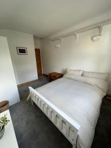 a bedroom with a white bed and a table at Room In Hackney in London