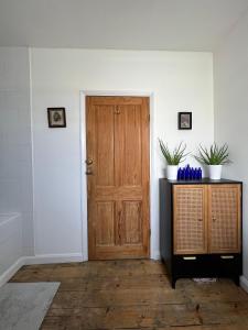 a room with a wooden door and a table with plants at Room In Hackney in London