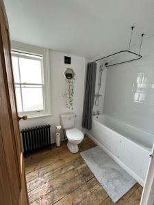 a bathroom with a toilet and a tub and a sink at Room In Hackney in London