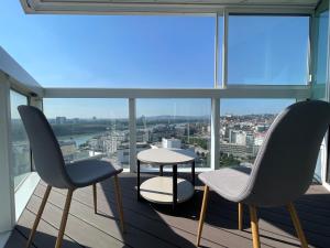 2 stoelen en een tafel op een balkon met uitzicht bij Panorama Apartment 3 rooms 19th floor Great view Free parking in Bratislava