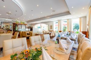 uma sala de jantar com uma mesa longa e cadeiras em Hotel Restaurant Bismarckturm em Aachen