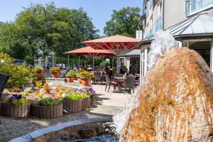 una fuente frente a un edificio con flores en Hotel Restaurant Bismarckturm en Aquisgrán