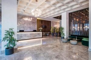 a lobby with a reception desk and potted plants at Tbilisi Philharmonic Hotel by Mercure in Tbilisi City