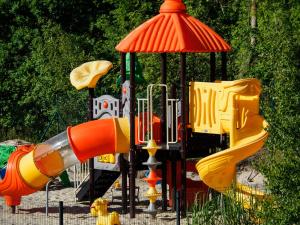um parque infantil com escorregas coloridos e uma estrutura de jogos em Natura Mierzei 30 em Krynica Morska