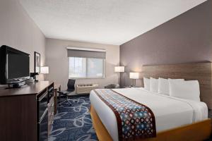 a hotel room with a bed and a flat screen tv at Baymont by Wyndham Waterloo in Waterloo