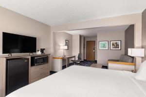 a hotel room with a bed and a flat screen tv at Baymont by Wyndham Waterloo in Waterloo