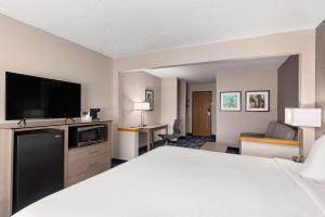 een hotelkamer met een bed en een flatscreen-tv bij Baymont by Wyndham Waterloo in Waterloo