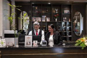 a man and woman sitting at a counter in a store at Hotel Restaurant Bismarckturm in Aachen